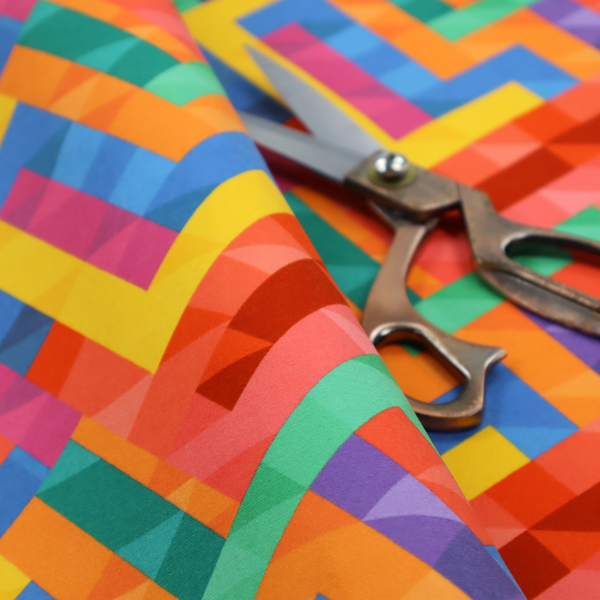 This fabric features a vibrant, geometric, and modular design that creates a dynamic, three-dimensional effect.
