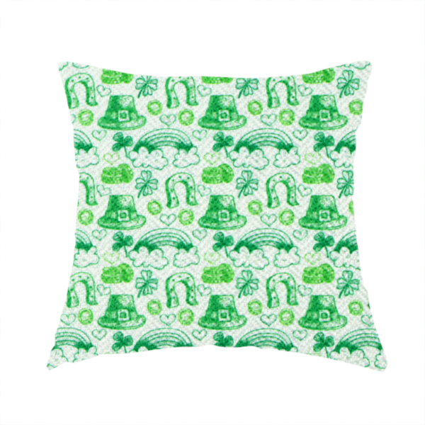 The fabric used to create this handmade cushion is a seamless St. Patrick’s Day fabric pattern featuring hand-sketched green icons including leprechaun top hats, lucky horseshoes, rainbows over clouds, four-leaf clovers, and small gold coins on a white textured background.