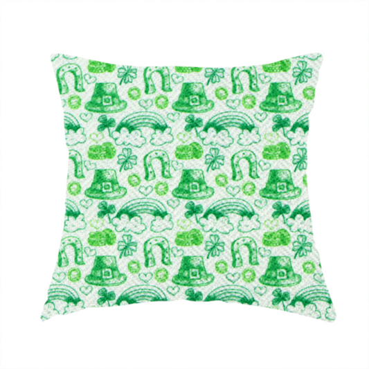 The fabric used to create this handmade cushion is a seamless St. Patrick’s Day fabric pattern featuring hand-sketched green icons including leprechaun top hats, lucky horseshoes, rainbows over clouds, four-leaf clovers, and small gold coins on a white textured background.