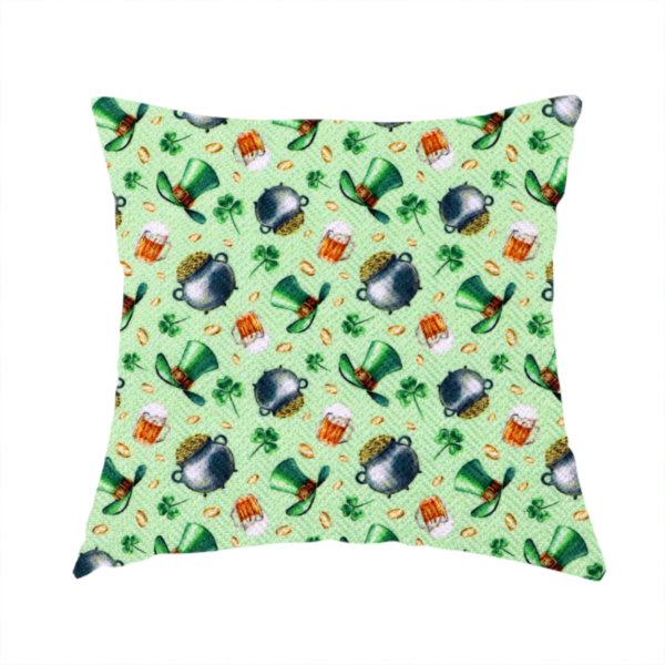 The fabric used to create these handmade cushions is a high-detail St. Patrick's Day fabric pattern on a light green textured background. The print features iron cauldrons overflowing with gold coins, frothy beer mugs, green leprechaun top hats with gold buckles, and scattered four-leaf clovers.