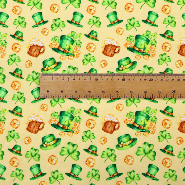 Seamless St. Patrick’s Day fabric pattern on a warm buttercream yellow background. Features watercolour-style green leprechaun top hats, wooden beer steins with foam, overflowing gold coins, and bright green shamrocks.