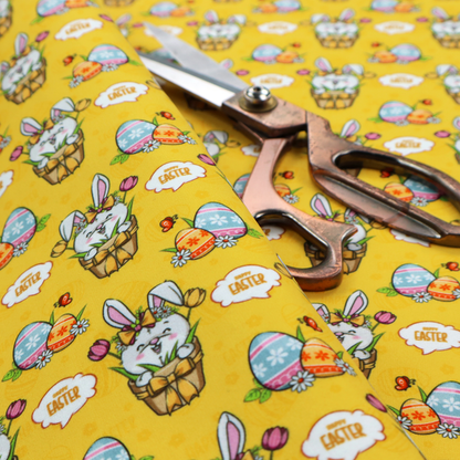This is a vibrant, repetitive Easter-themed pattern fabric, set against a bright mustard-yellow background. The design features several recurring hand-drawn, cartoon-style illustrations.