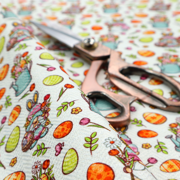 This fabric features a playful and detailed Easter garden pattern set against a crisp, white background. The design is a bright and busy "tossed" print that combines the popular gnome trend with traditional spring motifs.