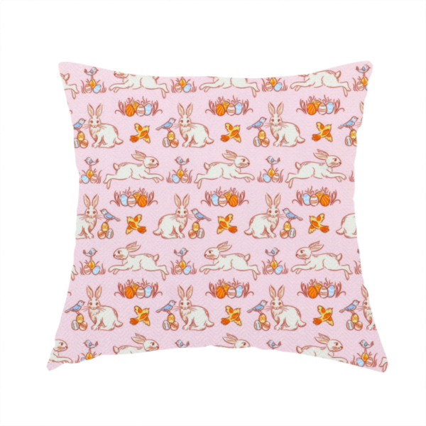 The fabric used to create these handmade cushions features a vintage-style Easter meadow pattern on a soft, blush-pink background. The design is reminiscent of classic children’s book illustrations, using fine, orange-brown linework and a muted pastel palette.