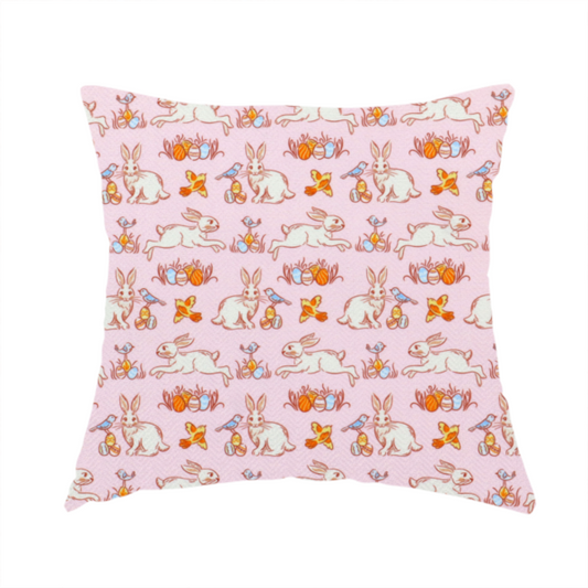 The fabric used to create these handmade cushions features a vintage-style Easter meadow pattern on a soft, blush-pink background. The design is reminiscent of classic children’s book illustrations, using fine, orange-brown linework and a muted pastel palette.
