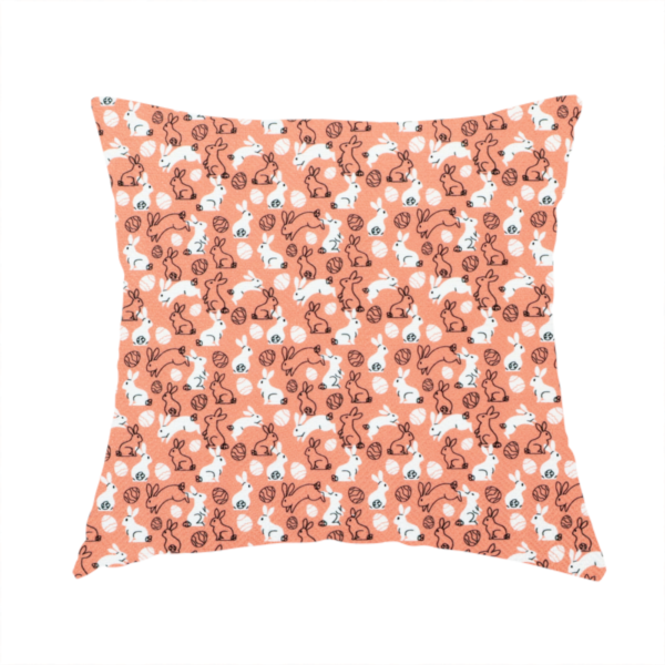 The fabric used to create these handmade cushions features a graphic, contemporary Easter pattern set against a warm, terracotta-orange background. The design is characterized by its clean, high-contrast motifs and a limited, modern colour palette.