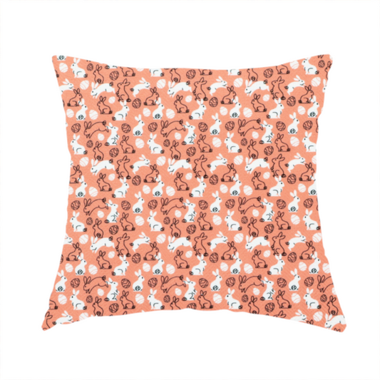 The fabric used to create these handmade cushions features a graphic, contemporary Easter pattern set against a warm, terracotta-orange background. The design is characterized by its clean, high-contrast motifs and a limited, modern colour palette.