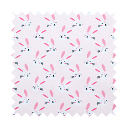 This fabric features a modern, minimalist bunny pattern set against a soft, pale pink background. The design is clean and contemporary, focusing on a repeating motif of stylized rabbit faces.