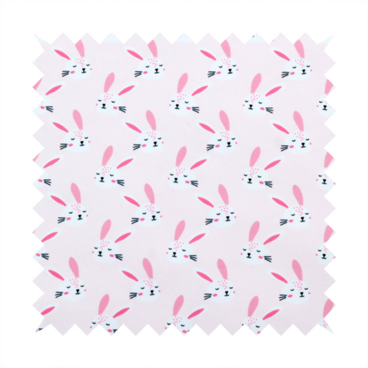 This fabric features a modern, minimalist bunny pattern set against a soft, pale pink background. The design is clean and contemporary, focusing on a repeating motif of stylized rabbit faces.