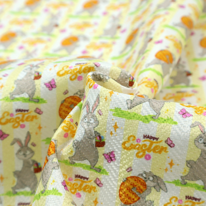 This fabric features a cheery and active Easter bunny pattern set against a vertical striped background of pale yellow and white. The design has a classic animated feel, full of personality and holiday spirit.