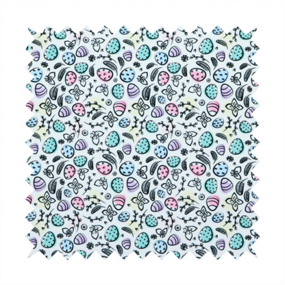 This fabric features an artistic, hand-illustrated Easter egg pattern on a cool, pale blue background. The design has a sketchbook or "doodle" quality, with expressive black ink outlines and soft watercolour-style colour accents.