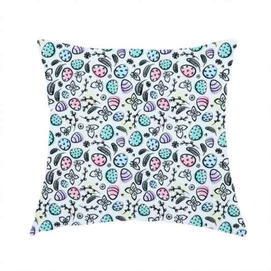 The fabric used to create these handmade cushions features an artistic, hand-illustrated Easter egg pattern on a cool, pale blue background. The design has a sketchbook or "doodle" quality, with expressive black ink outlines and soft watercolour-style colour accents.