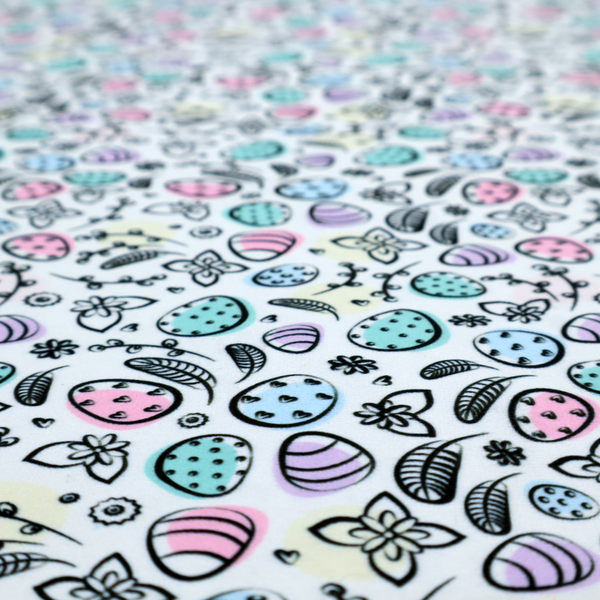 This fabric features an artistic, hand-illustrated Easter egg pattern on a cool, pale blue background. The design has a sketchbook or "doodle" quality, with expressive black ink outlines and soft watercolour-style colour accents.