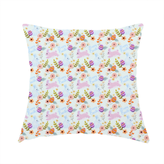 The fabric used to create this handmade cushion features a sweet, pastoral Easter pattern on a crisp, white background. The design has a classic, gentle feel, combining soft pastel illustrations with delicate floral arrangements.