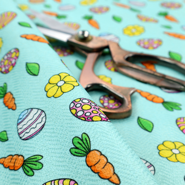 This fabric features a bright and cheerful Easter garden pattern set against a refreshing sky-blue background. The design is clean and energetic, using a cartoon-style illustration technique with bold black outlines.