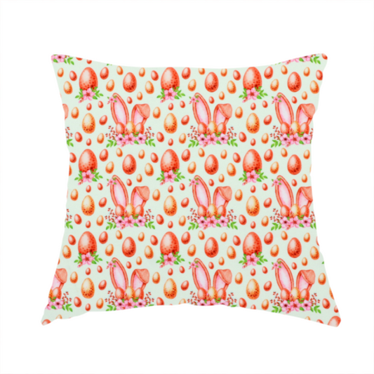 The fabric used to create this handmade cushion features a warm, watercolour-style Easter pattern on a very pale mint-green background. The design is rich in texture and soft tones, giving it a cosy and traditional holiday feel.