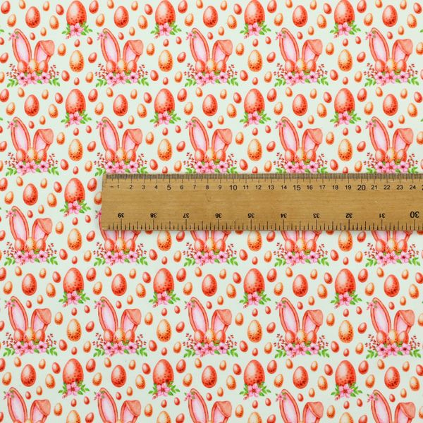 This fabric features a warm, watercolour-style Easter pattern on a very pale mint-green background. The design is rich in texture and soft tones, giving it a cosy and traditional holiday feel.