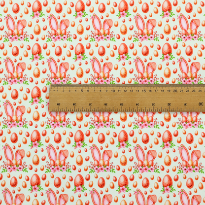This fabric features a warm, watercolour-style Easter pattern on a very pale mint-green background. The design is rich in texture and soft tones, giving it a cosy and traditional holiday feel.