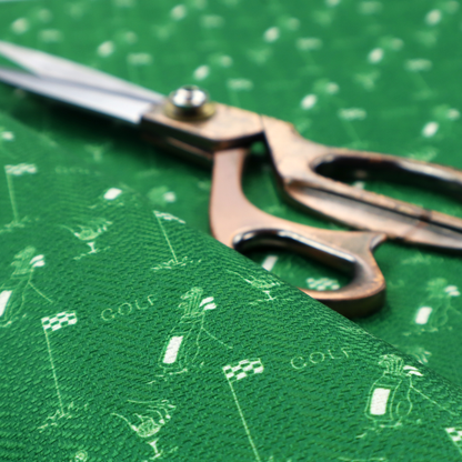 A repeating fabric pattern on a solid emerald green background, featuring small white icons of golf bags, checked flags, and the word 'GOLF' in a clean, sans-serif font.
