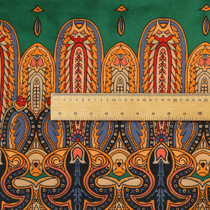 Ornate jewel-toned border print fabric with a central green stripe flanked by intricate Persian-inspired teardrop and medallion motifs in amber and navy.