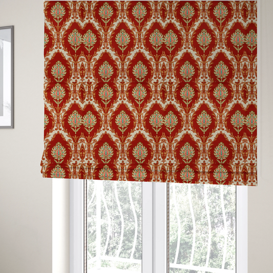 The fabric used to create these Roman blinds is a grand, symmetrical damask-style fabric on a rich crimson red ground featuring ornate cream-colored leaf frames enclosing vibrant, stylized floral pinecones with teal and pink accents.