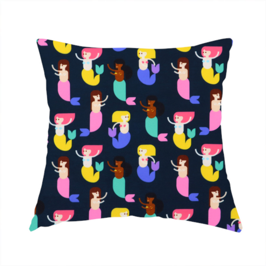 The fabric used to create this handmade cushion is a fun and vibrant children's fabric on a deep midnight-navy background. The pattern features a diverse cast of illustrated mermaids with various skin tones, hair colours (pink, blonde, brown), and colourful tails in shades of mint, yellow, pink, and purple, arranged in a cheerful repeating grid.