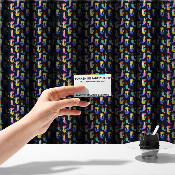 The fabric used to create these made-to-measure curtains is a  fun and vibrant children's fabric on a deep midnight-navy background. The pattern features a diverse cast of illustrated mermaids with various skin tones, hair colours (pink, blonde, brown), and colourful tails in shades of mint, yellow, pink, and purple, arranged in a cheerful repeating grid.