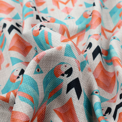 A modern and vibrant geometric fabric on a textured, off-white linen-look background. The design features a symmetrical repeat of abstract parrots rendered in sharp, angular 'prism' shapes of turquoise, coral-pink, and charcoal black. Interspersed between the birds are large coral diamonds and teal triangles, creating a balanced, contemporary tribal-pop aesthetic.