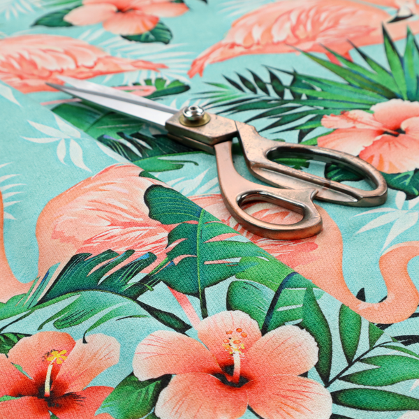 A vibrant tropical pattern featuring pink flamingos, orange hibiscus flowers, and lush green palm leaves on a bright turquoise background.