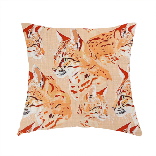 The fabric used to create this handmade cushion is a repeating pattern of illustrated wild cat heads, such as lynxes or bobcats, in shades of orange and cream on a light peach-coloured fabric with a subtle linen-like texture.