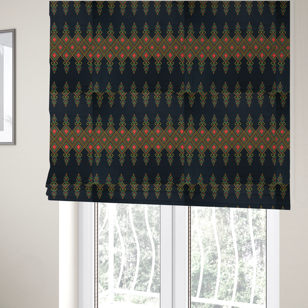 The fabric used to create these Roman blinds is a geometric tribal pattern featuring red, yellow, and green diamonds and linear motifs on a dark charcoal-black fabric background.