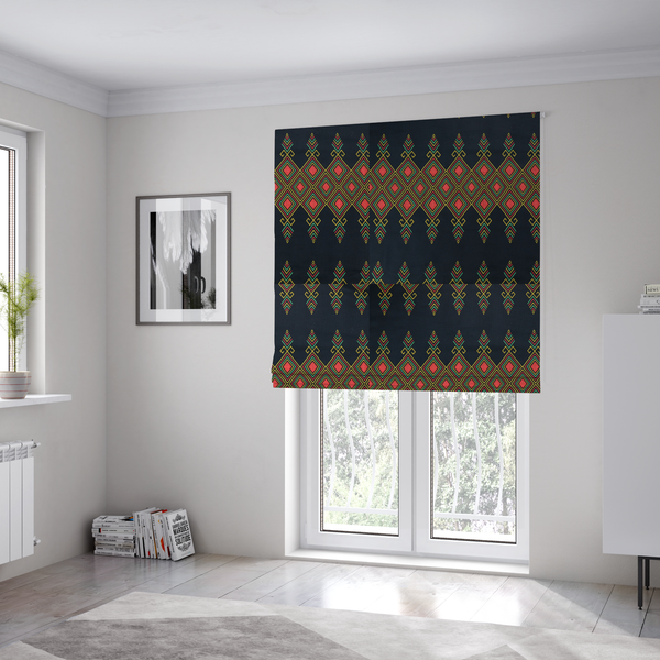 The fabric used to create these Roman blinds is a geometric tribal pattern featuring red, yellow, and green diamonds and linear motifs on a dark charcoal-black fabric background.