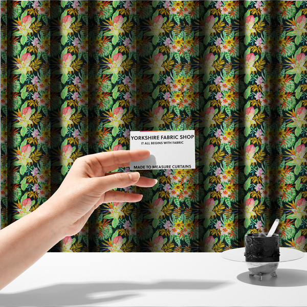 The fabric used to create these made-to-measure curtains is a vivid tropical botanical pattern featuring lilies, birds of paradise, and pink plumeria blossoms set against lush green leaves on a deep midnight black background.