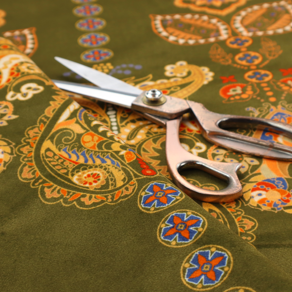 An intricate, bohemian-inspired pattern featuring ornate paisley motifs and stylized floral medallions in warm ochre, terracotta, and cerulean blue on a rich olive green background.