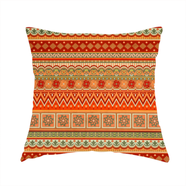 The fabric used to create this handmade cushion is a vibrant, tribal-inspired geometric pattern featuring horizontal bands of zig-zags, floral tiles, and ornamental borders in a warm palette of terracotta, burnt orange, and sage green.