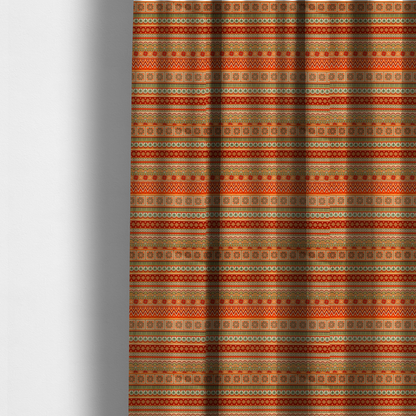 The fabric used to create these made-to-measure curtains is a vibrant, tribal-inspired geometric pattern featuring horizontal bands of zig-zags, floral tiles, and ornamental borders in a warm palette of terracotta, burnt orange, and sage green.