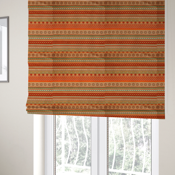 The fabric used to create these Roman blinds is a vibrant, tribal-inspired geometric pattern featuring horizontal bands of zig-zags, floral tiles, and ornamental borders in a warm palette of terracotta, burnt orange, and sage green.