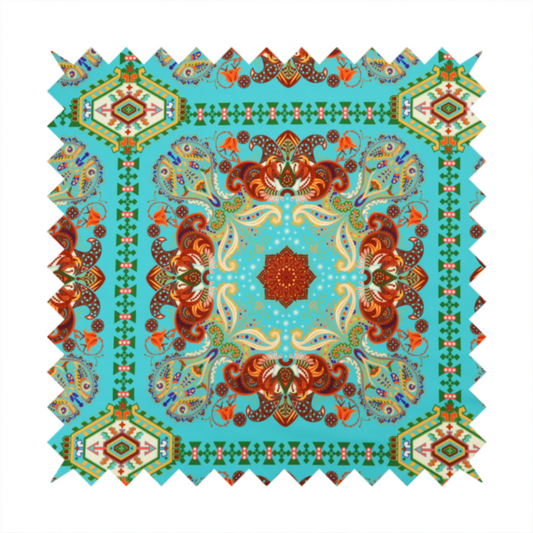 A vibrant and detailed ornamental fabric on a bright turquoise-azure background. The design features a large, symmetrical Persian-style medallion composed of warm terracotta, orange, and gold paisley motifs, framed by vertical geometric borders and diamond-shaped emblems in emerald green and ivory.