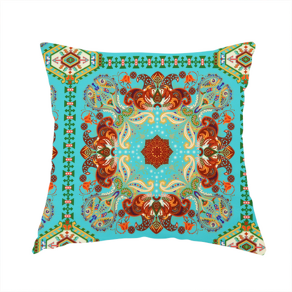 The fabric used to create this handmade cushion is a vibrant and detailed ornamental fabric on a bright turquoise-azure background. The design features a large, symmetrical Persian-style medallion composed of warm terracotta, orange, and gold paisley motifs, framed by vertical geometric borders and diamond-shaped emblems in emerald green and ivory.