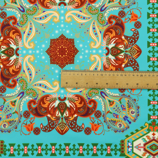 A vibrant and detailed ornamental fabric on a bright turquoise-azure background. The design features a large, symmetrical Persian-style medallion composed of warm terracotta, orange, and gold paisley motifs, framed by vertical geometric borders and diamond-shaped emblems in emerald green and ivory.