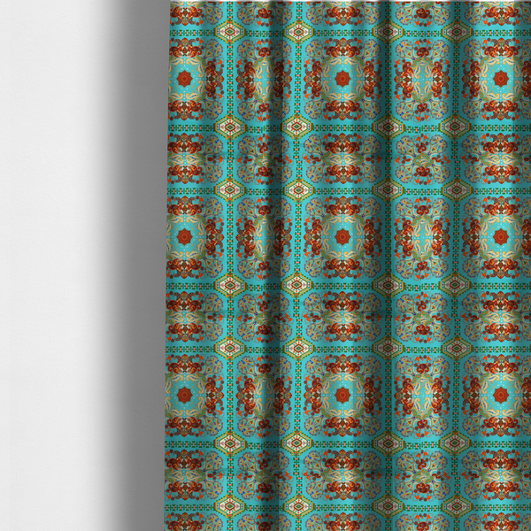 The fabric used to create these made-to-measure curtains is a vibrant and detailed ornamental fabric on a bright turquoise-azure background. The design features a large, symmetrical Persian-style medallion composed of warm terracotta, orange, and gold paisley motifs, framed by vertical geometric borders and diamond-shaped emblems in emerald green and ivory.