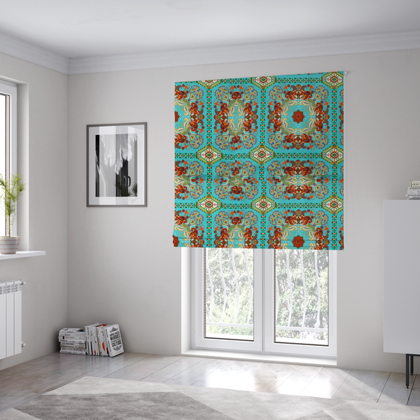 The fabric used to create these Roman blinds is a vibrant and detailed ornamental fabric on a bright turquoise-azure background. The design features a large, symmetrical Persian-style medallion composed of warm terracotta, orange, and gold paisley motifs, framed by vertical geometric borders and diamond-shaped emblems in emerald green and ivory.