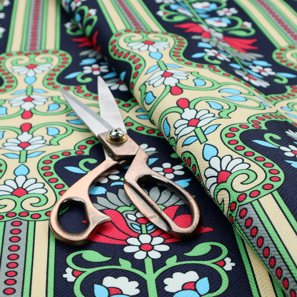 This fabric is a highly detailed, symmetrical textile pattern with a dark navy blue background. The design consists of repeating vertical floral motifs arranged in columns, separated by narrow, light-coloured striped bands.