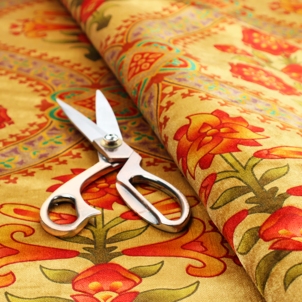 Ornate Gothic Revival fabric pattern featuring red and orange Tudor rose medallions framed by a gold ogival diamond lattice with teal accents.
