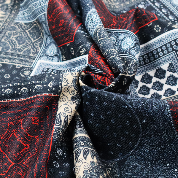 A patchwork-style fabric print featuring a repetitive arrangement of square and rectangular blocks. Each block is filled with intricate navy blue, red, and cream-coloured bandana and paisley motifs, creating a dense, geometric, and traditional textile pattern.