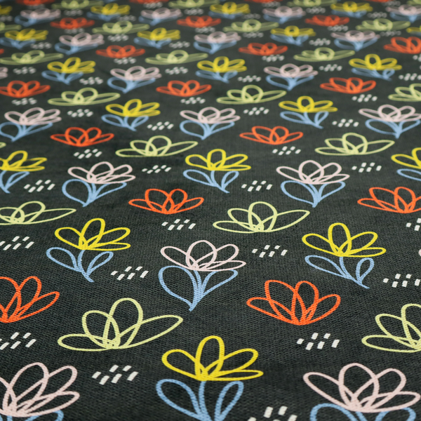 A black fabric print featuring a modern, repeating pattern of colourful doodle-style floral outlines. The flowers are drawn in vibrant yellow, orange, pink, and light blue, accented by small white dash marks, creating a playful and artistic aesthetic.