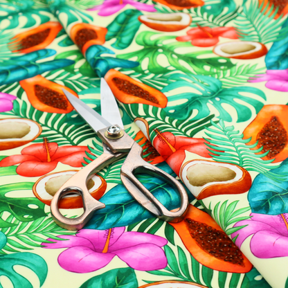 A lush, tropical-themed fabric print featuring a repeating pattern of halved papayas, coconuts, vibrant red and pink hibiscus flowers, and various green palm and monstera leaves against a light cream-colored background. The design has a hand-painted, watercolour style, creating a fresh, summery, and vacation-inspired aesthetic.
