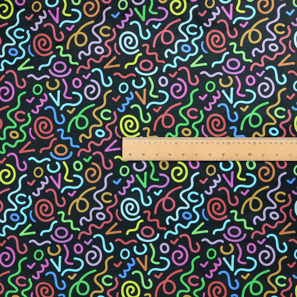 A black fabric print featuring a retro, 90s-inspired pattern of colourful, hand-drawn-style doodles. The design includes vibrant neon swirls, squiggles, and V-shapes in shades of pink, yellow, blue, orange, and green, creating a nostalgic, high-energy, and playful aesthetic.