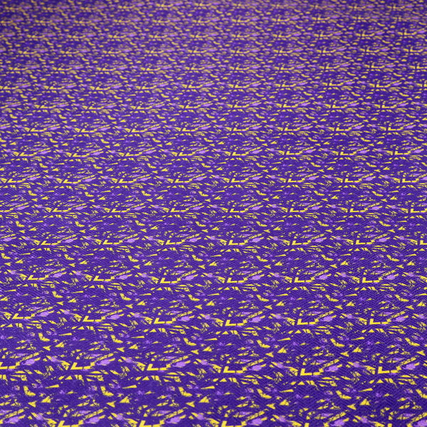 A vibrant fabric print featuring a dense, abstract pattern of bright yellow, sharp-edged shapes scattered across a deep, solid purple background. The design creates a textured, dynamic, and modern look.