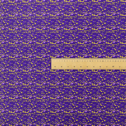 A vibrant fabric print featuring a dense, abstract pattern of bright yellow, sharp-edged shapes scattered across a deep, solid purple background. The design creates a textured, dynamic, and modern look.
